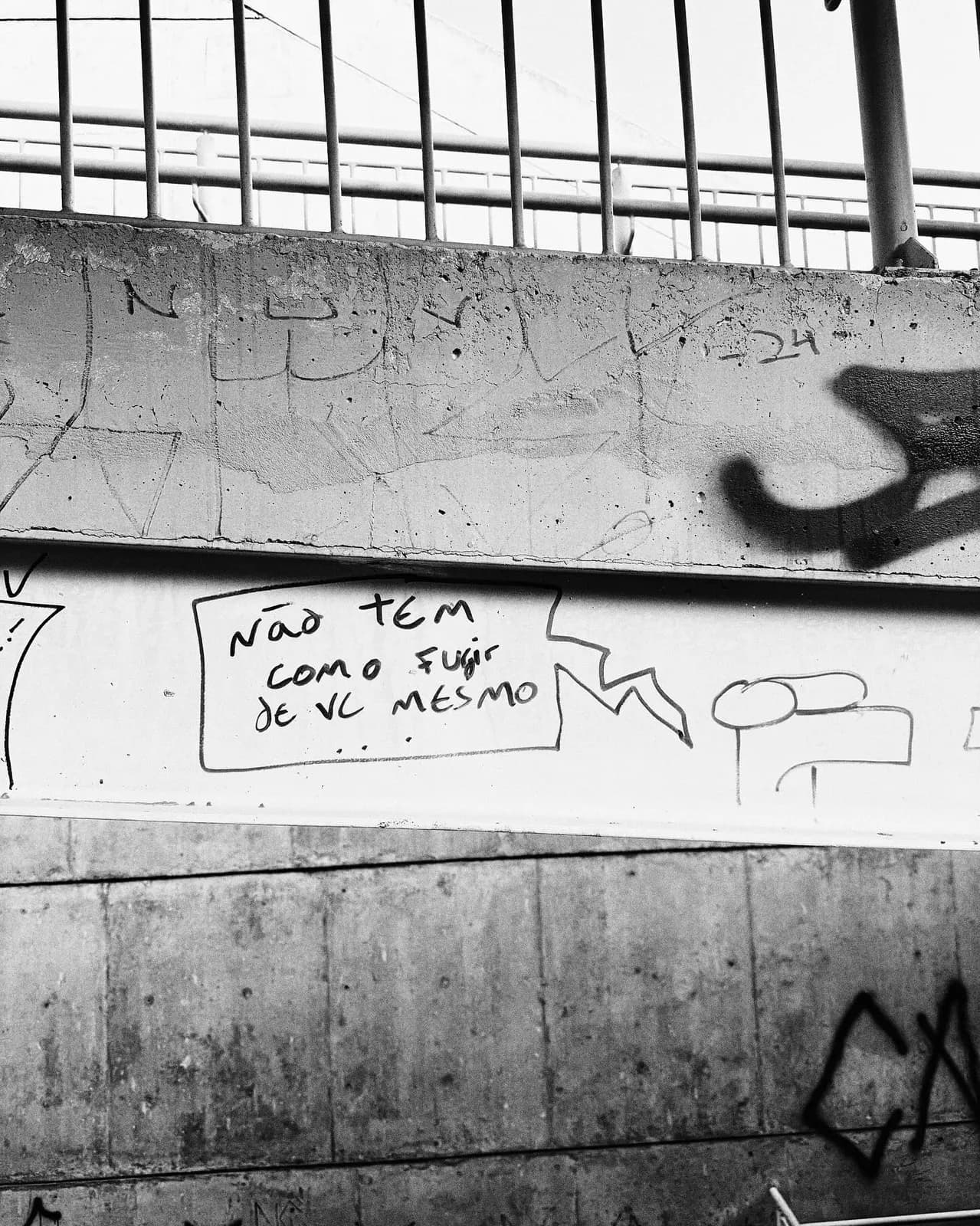 Muro debaixo do viaduto com a frase escrita à mão.